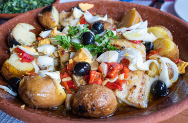 Portuguese food: casserole with cod, potatoes, onion, egg, red pepper, olives and coriander