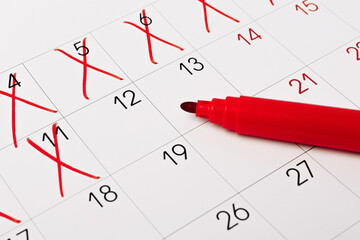 close up of a calendar page with red pen
