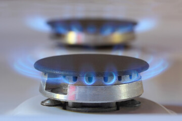 Kitchen gas burners with blue flames of natural gas, domestic equipment with propane or methane gas