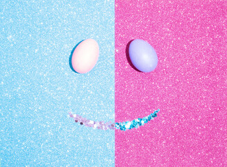 Smiling face made of Easter eggs and glitter on shiny background. Easter minimal concept. Flat lay.