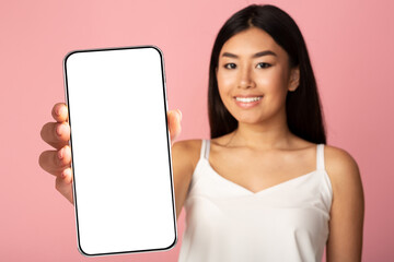 Pretty asian woman showing smarptone with blank screen