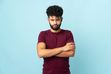 Young Moroccan man isolated on blue background feeling upset