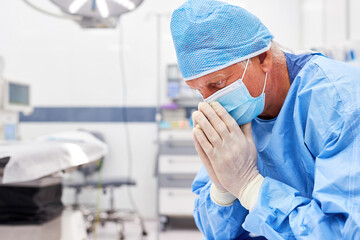 Exhausted and worried surgeon is sitting in the operating room