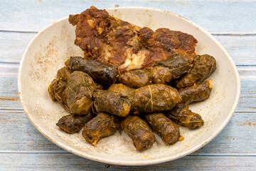 Meat leaf wrapping. Traditional Mediterranean flavor. Wrapping leaves on a blue wooden background. local name etli yaprak sarma