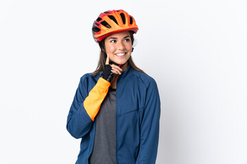 Young cyclist brazilian girl isolated on white  background thinking an idea while looking up