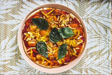 vegan margherita pizza with cherry tomatos and basil leaves topping, healthy plant-based food
