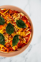 vegan margherita pizza with cherry tomatos and basil leaves topping, healthy plant-based food
