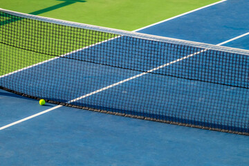 Artificial tennis court. View of the ball lying at the net.  Very bright colors