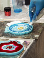 The art process of pouring epoxy resin into a wooden toy. Technology process of creating a painting...
