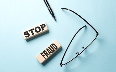 STOP FRAUD text on the wooden block ,blue background