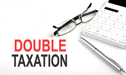 DOUBLE TAXATION Concept. Calculator,pen and glasses on white background