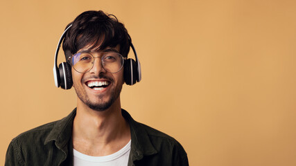 Laughing arabic guy enjoying brand new wireless headset