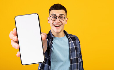 Funny guy nerd showing cellphone with empty screen - obrazy, fototapety, plakaty