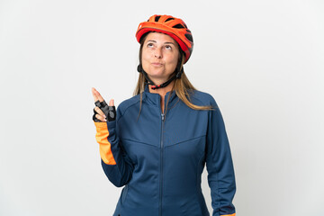 Middle age cyclist woman isolated on white background with fingers crossing and wishing the best