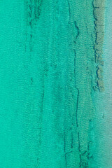 Fototapeta na wymiar Background, texture of relaxing, calm turquoise, transparent sea water with stones, slabs, lump, coral. Summer vacation. Blue ocean lagoon. Drone, copter top view.