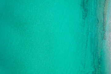 Fototapeta na wymiar Background, texture of relaxing, calm turquoise, transparent sea water with stones, slabs, lump, coral. Summer vacation. Blue ocean lagoon. Drone, copter top view.