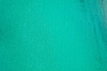 Background, texture of relaxing, calm turquoise, transparent sea water with stones, slabs, lump, coral. Summer vacation. Blue ocean lagoon. Drone, copter top view.