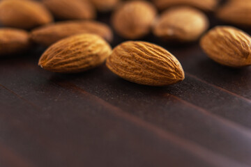 Macro of almonds on dark wooden table. Organic health protein vegetarian food. Background copy space