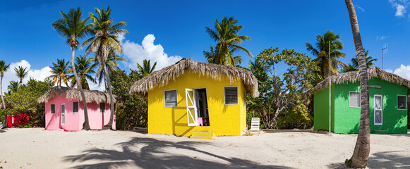 Isla Catalina, bunte Häuser zwischen Palmen am Strand der karibischen Insel in der Dominikanischen Republik, Panorama.