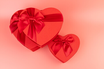 Red box in shape of heart. Gift box for Valentine's Day. Isolated on pink background.