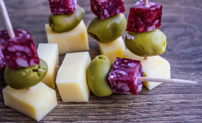 Light snack from cheese, salami and olive