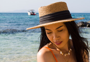 Portrait of woman on the beach with a hat
