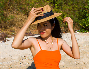 Portrait of woman on the beach with a hat