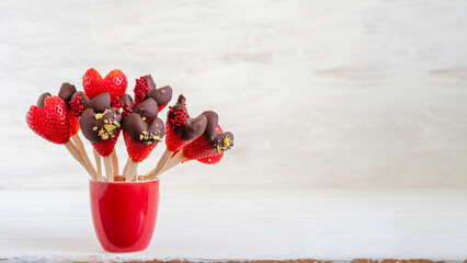Chocolate covered strawberries for Valentine's Day on white wooden background.