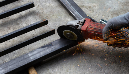 Close up, A man working with angle grinder. Iron gate repair