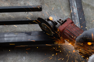 Close up, A man working with angle grinder. Iron gate repair