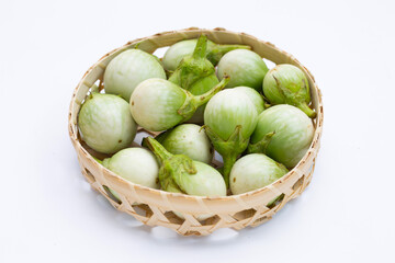Organic green eggplant in bamboo basket on white background