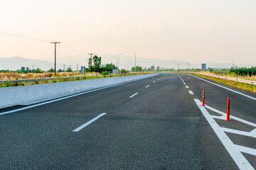 Fototapeta premium Driving car on a highway with view on scenic hills and mountains, European road