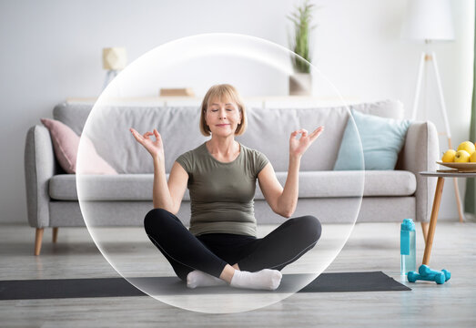 Serene calm contented happy mature european woman meditating in living room interior in protective bubble