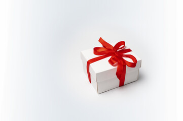 Top view of a white gift box with a red bow on a white background. Banner with copy space