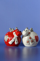 Valentine's Day congratulation card. Two funny figures of red and white deers in love on a blue background. Text space.