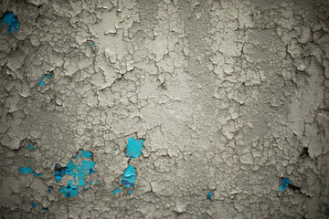 Old paint on wall. Texture of flying paint is gray. Simple background.