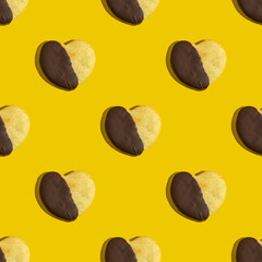 Seamless pattern with chocolate covered cookie in the form of heart for Valentine's Day on yellow background.