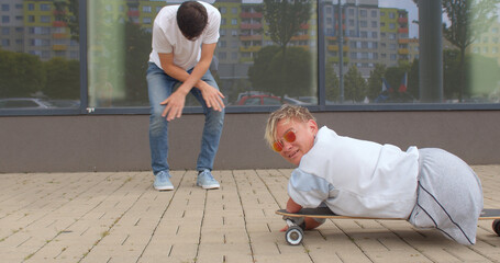 A happy disabled woman rides a skateboard during active funny games with a friend.