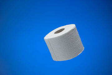 Generic multi layer white toilet paper roll. Close up studio shot, isolated on blue background, no people
