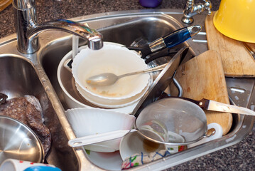 Dirty dishes in the kitchen sink. Homework in the kitchen.