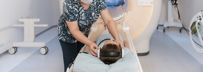 Doctor or nurse and patient with tomography CT or MRI Scan in hospital. Interior of radiography...