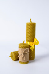 composition of three wax candles on a white background. natural beeswax. handmade candles
