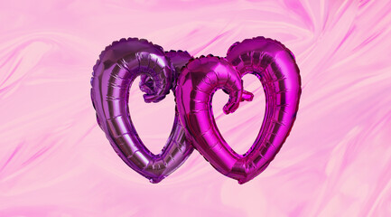 Two foil heart shaped pink and violet balloons floating against silk pink background. St Valentines Day greeting card or wedding concept. minimal