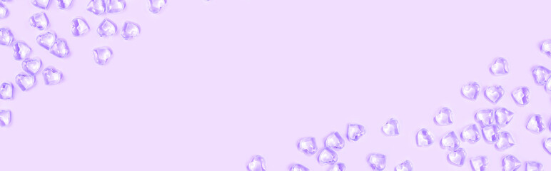 St Valentines day violet background border. Many glass hearts flat lay. Love or wedding concept