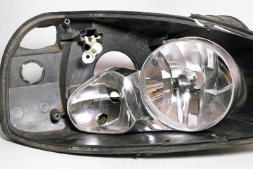 parts of disassembled headlight. cracked black plastic housing and lights reflector. closeup
