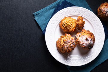 Food concept Homemade Caramel Choux a la cream or Choux cream puffs on dark background with copy space