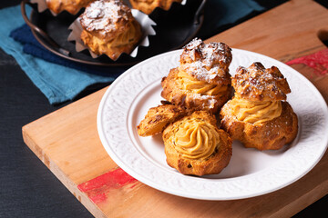 Food concept Homemade Caramel Choux a la cream or Choux cream puffs on dark background with copy space