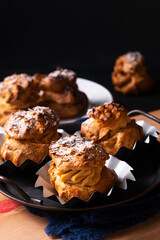 Food concept Homemade Caramel Choux a la cream or Choux cream puffs on dark background with copy space