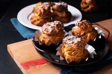 Food concept Homemade Caramel Choux a la cream or Choux cream puffs on dark background with copy space