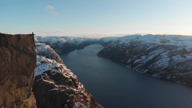 4k Aerial Pulpit Rock in Winter sunrise with man on edge